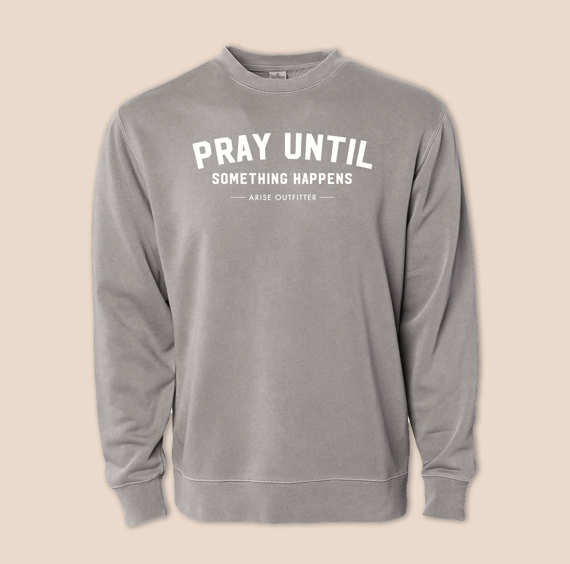 Gray sweatshirt with 'PRAY UNTIL SOMETHING HAPPENS' text on a beige background