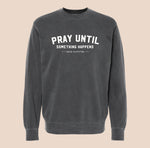 Black sweatshirt with 'Pray Until Something Happens' text on a beige background