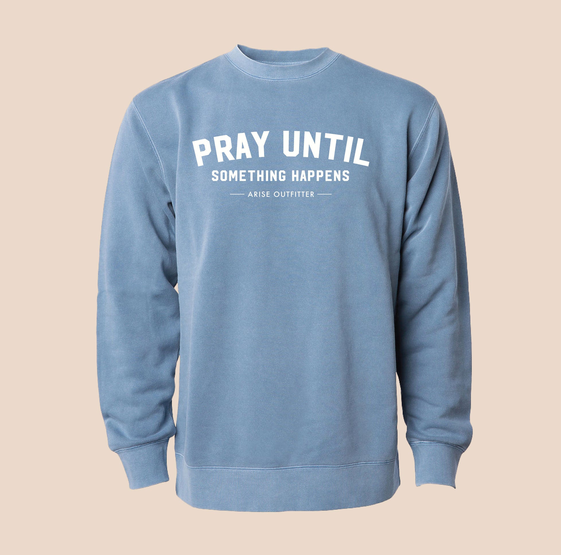 Blue sweatshirt with 'Pray Until Something Happens' text on a beige background