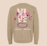 Beige sweatshirt with floral design and text on the back against a beige background